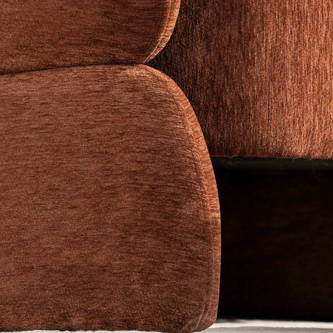 Sillón Hamburgo en cuarto beige, con pared blanca vista en detalle de una pata lateral