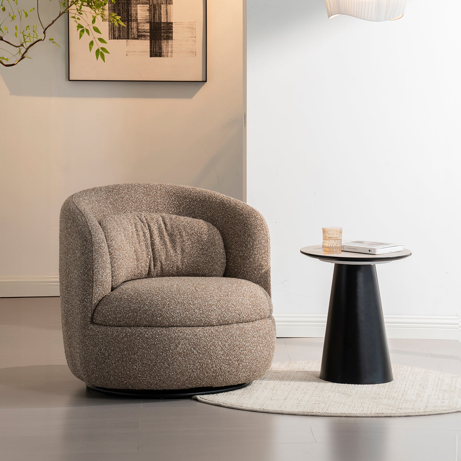 Sillón Victoria dentro de un cuarto con paredes blanca, debajo de un cuadro artístico, a lado una mesa lateral color negro con un vaso de agua y un libro