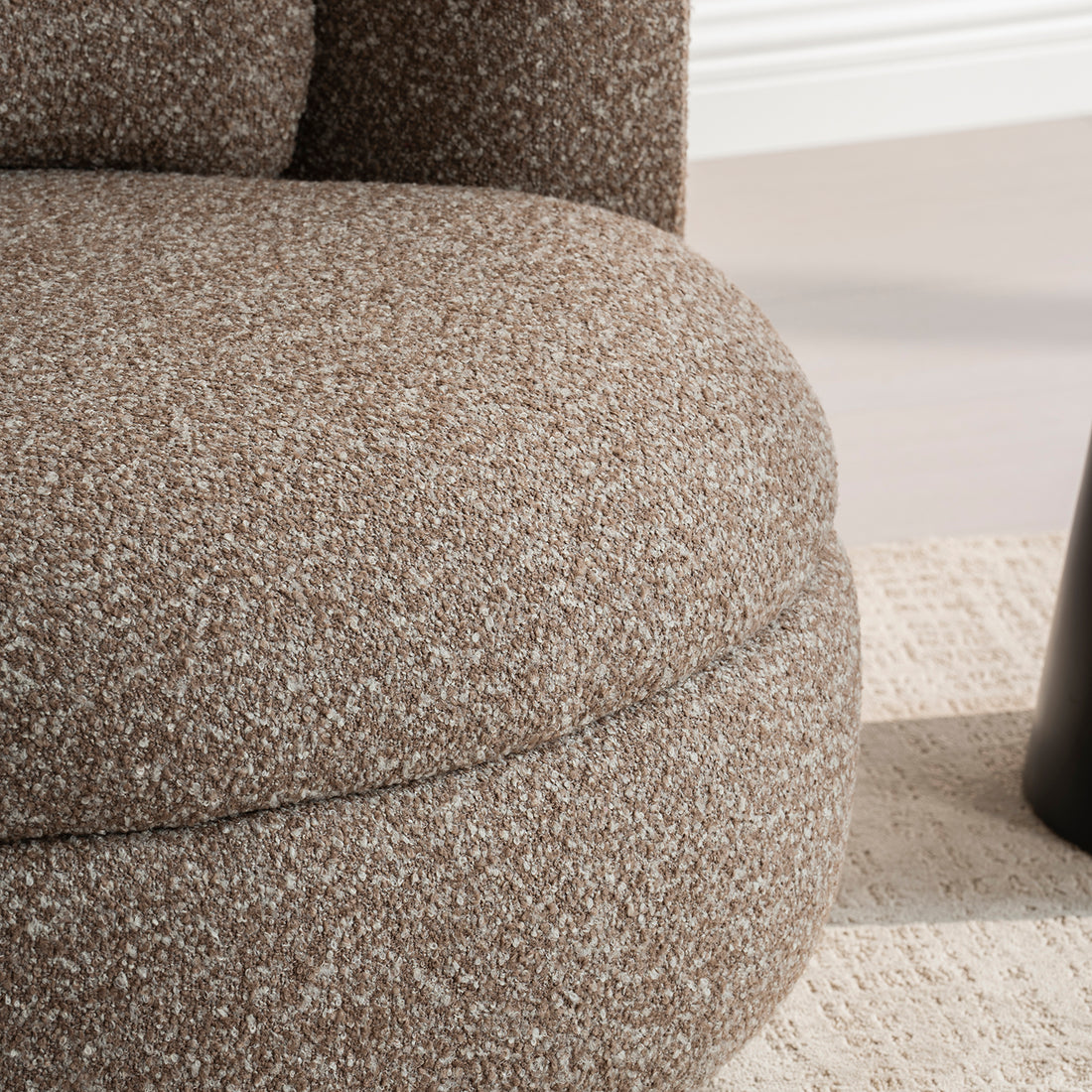 Sillón Victoria vista en detalle del asiento y parte de la base sobre alfombra color beige 