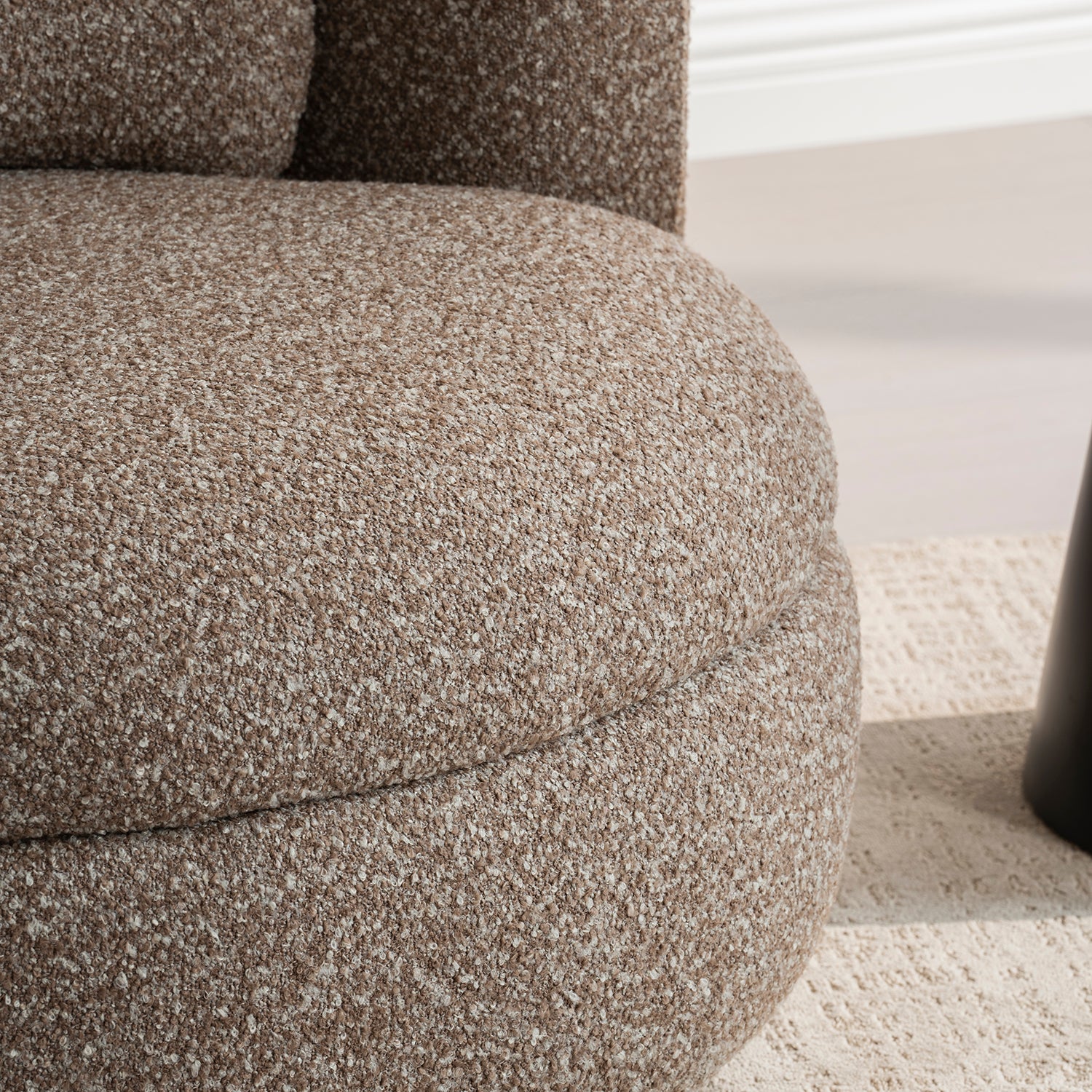Sillón Victoria vista en detalle del asiento y parte de la base sobre alfombra color beige 
